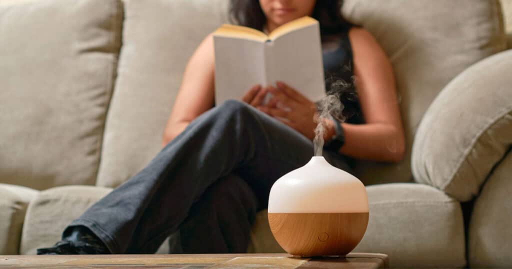 lady reading book with diffuser in the table