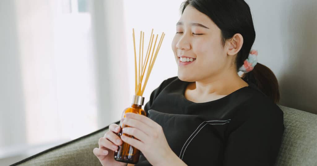 15 Best Reed Diffusers for Bathroom: A Buying Guide 31 lady smelling reed diffuser