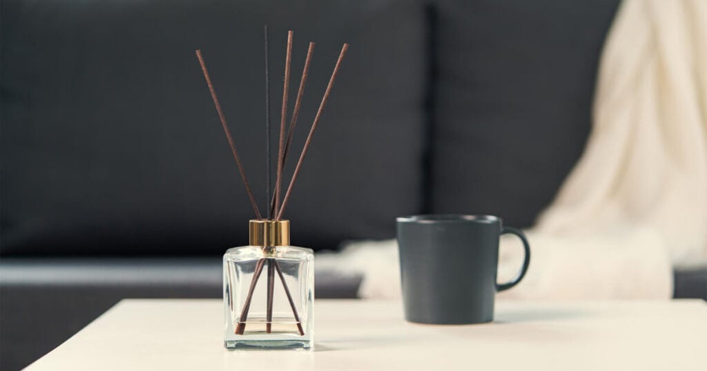 Budget vs Luxury Reed Diffusers: Are Premium Brands Really Worth It? 25 clear reed diffuser bottle in a white table with black mug