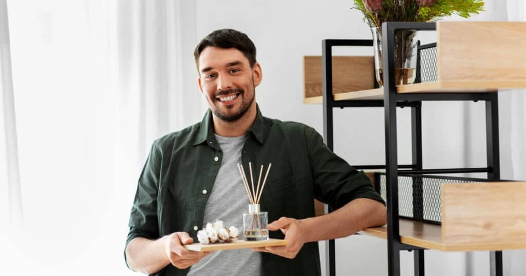 Budget vs Luxury Reed Diffusers: Are Premium Brands Really Worth It? 10 man holding a tray with reed diffuser and flower petals