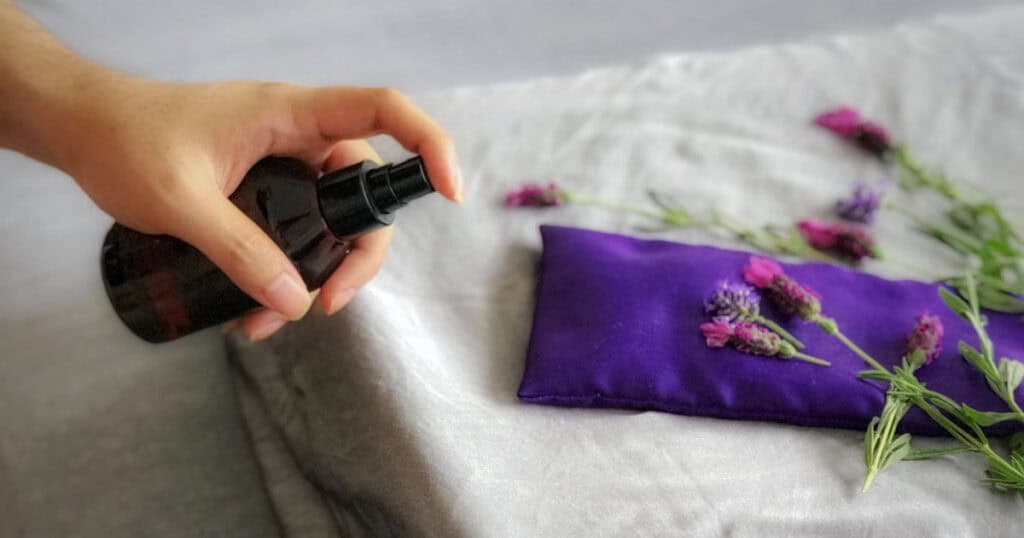 10 Best Linen Sprays to Freshen Your Sofa, Curtains, and Car 11 lady spraying linen spray on folded curtain
