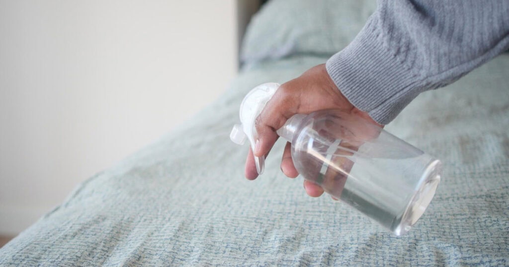 10 Best Linen Sprays to Freshen Your Sofa, Curtains, and Car 23 man spraying the bed sheets