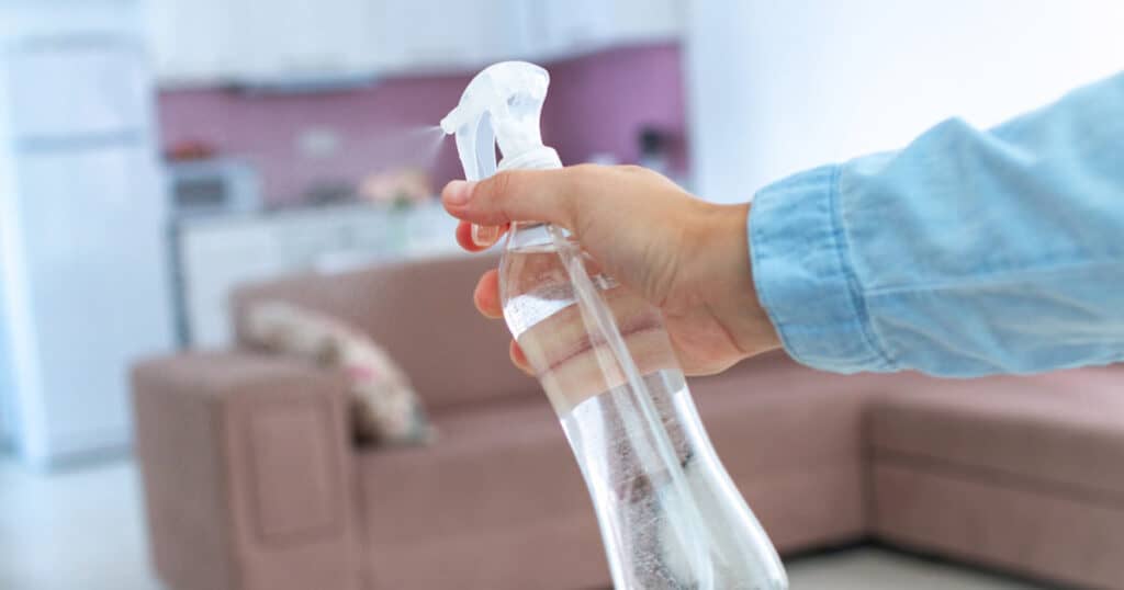 10 Best Linen Sprays to Freshen Your Sofa, Curtains, and Car 12 spraying linen spray in the living room